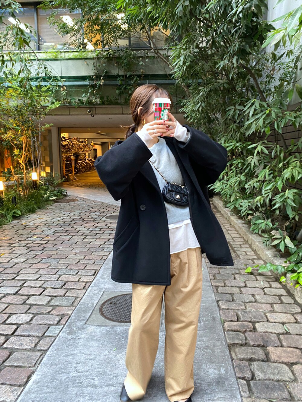 ブラック系のその他アウター、ベージュ系のチノパンツ、ホワイト系のTシャツ/カットソーを着用したレディースの秋コーディネートの3枚目の写真