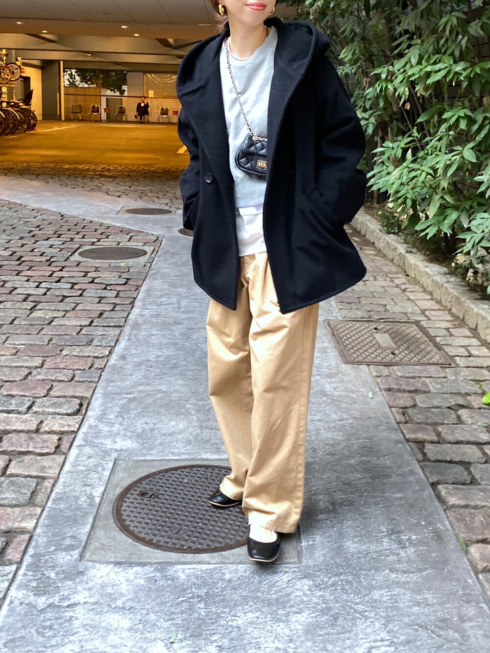 ブラック系のその他アウター、ベージュ系のチノパンツ、ホワイト系のTシャツ/カットソーを着用したレディースの秋コーディネートの2枚目の写真