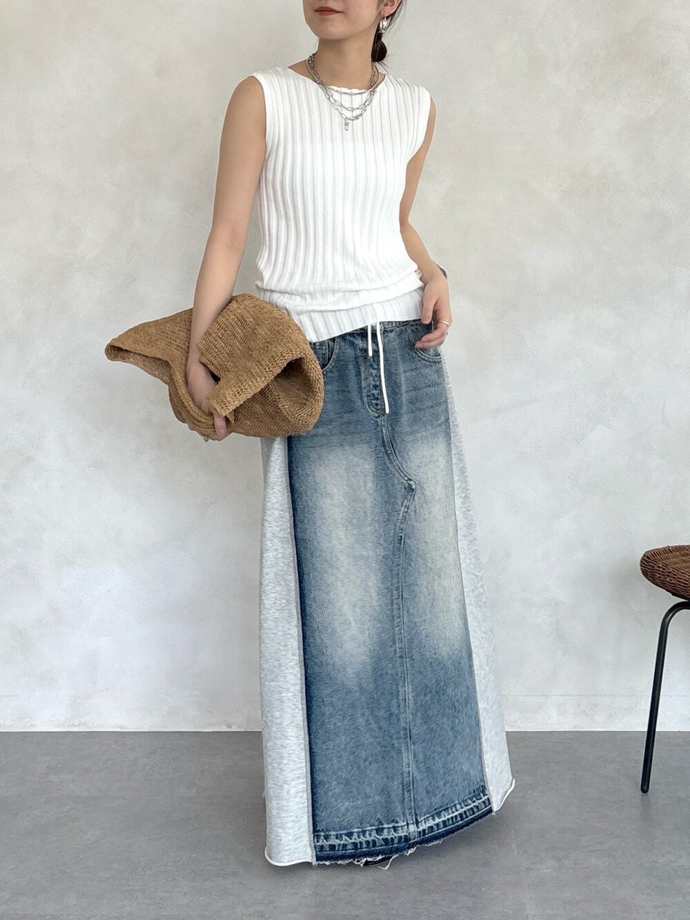 グレー系のスカート、ホワイト系のニット/セーター、シルバー系のネックレスを着用したレディースの春コーディネートの4枚目の写真