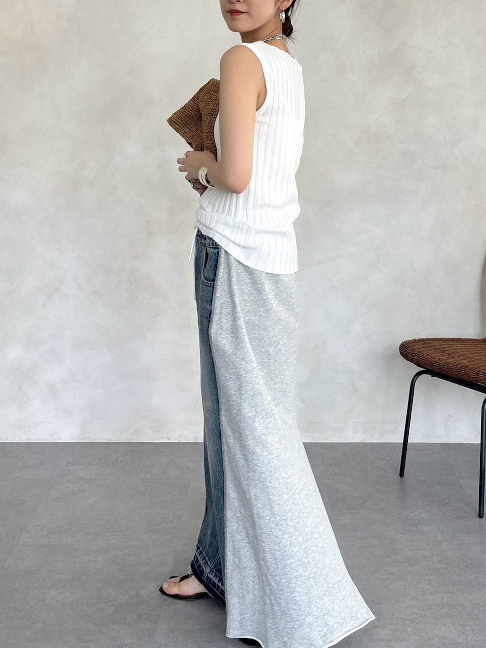 グレー系のスカート、ホワイト系のニット/セーター、シルバー系のネックレスを着用したレディースの春コーディネートの7枚目の写真