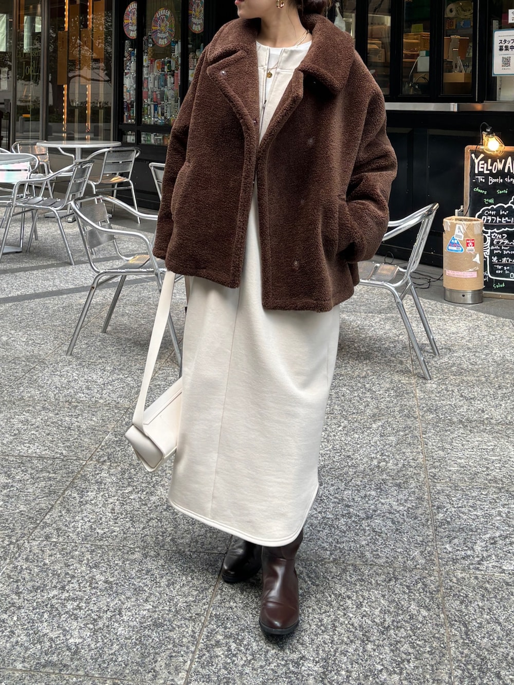 ブラウン系のその他アウター、ベージュ系のワンピース、ブラウン系のブーツを着用したレディースの冬コーディネートの2枚目の写真