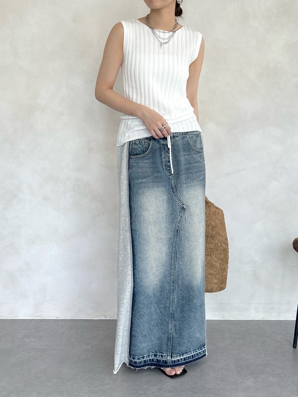 グレー系のスカート、ホワイト系のニット/セーター、シルバー系のネックレスを着用したレディースの春コーディネートの5枚目の写真