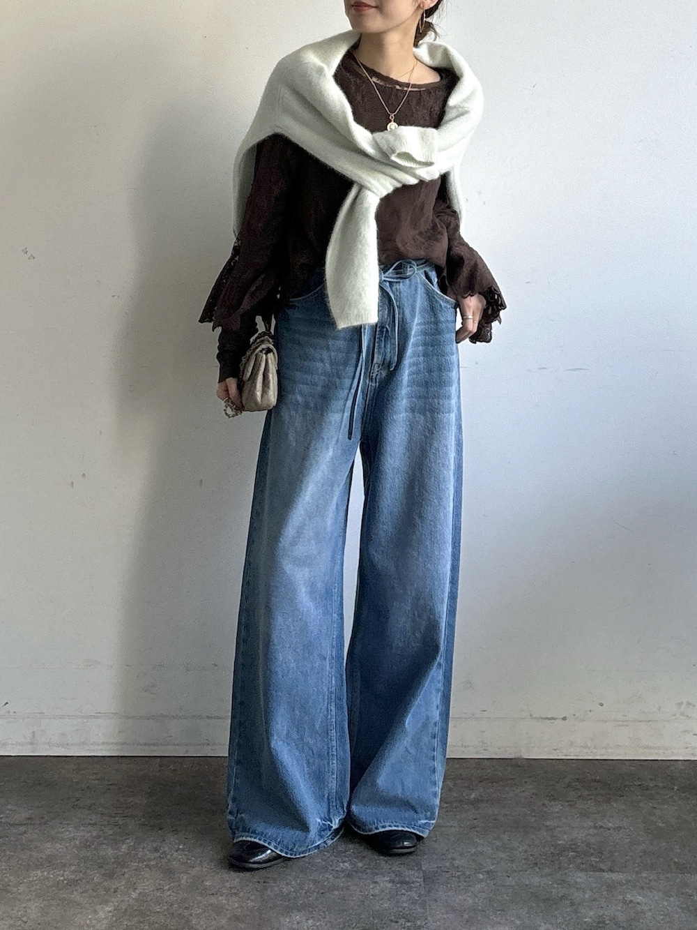 ブルー系のデニムパンツ、ブラウン系のシャツ/ブラウス、ブラウン系のTシャツ/カットソーを着用したレディースの冬コーディネートの2枚目の写真