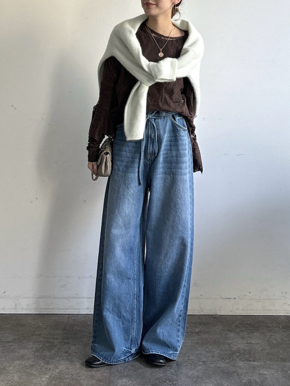 ブルー系のデニムパンツ、ブラウン系のシャツ/ブラウス、ブラウン系のTシャツ/カットソーを着用したレディースの冬コーディネートの3枚目の写真