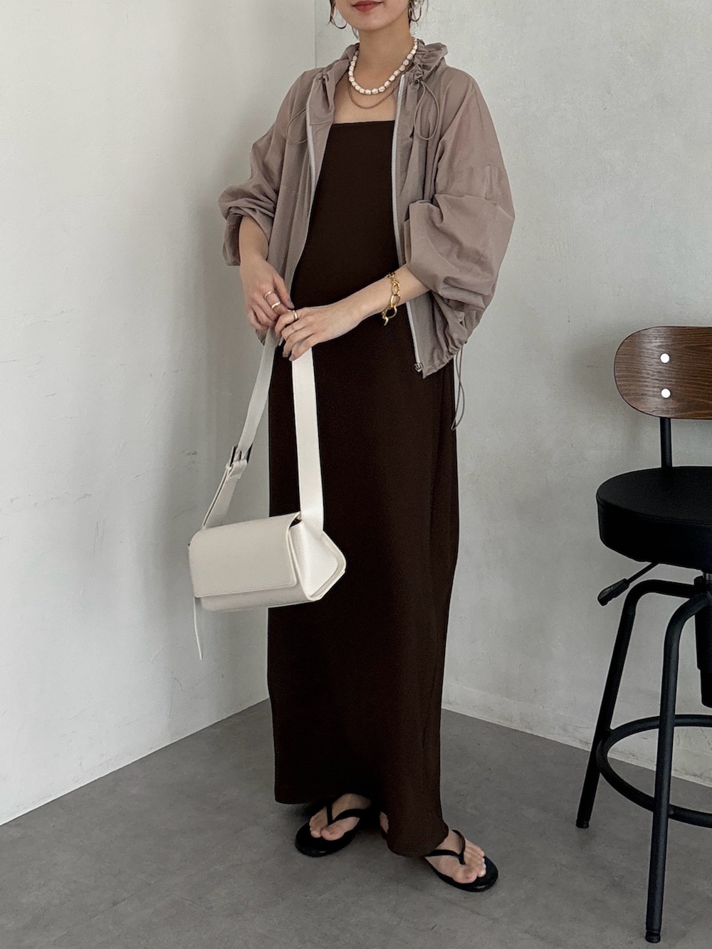 ブラウン系のワンピース、ベージュ系のその他アウター、ホワイト系のショルダーバッグを着用したレディースの夏コーディネートの3枚目の写真
