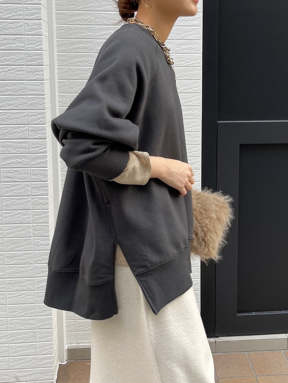 グレー系のTシャツ/カットソー、ホワイト系のスカート、ブラック系のブーツを着用したレディースの冬コーディネートの8枚目の写真