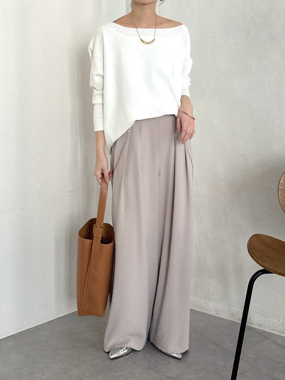 イエロー系のショルダーバッグ、ベージュ系のスラックス、ゴールド系のブレスレットを着用したレディースの冬コーディネートの4枚目の写真