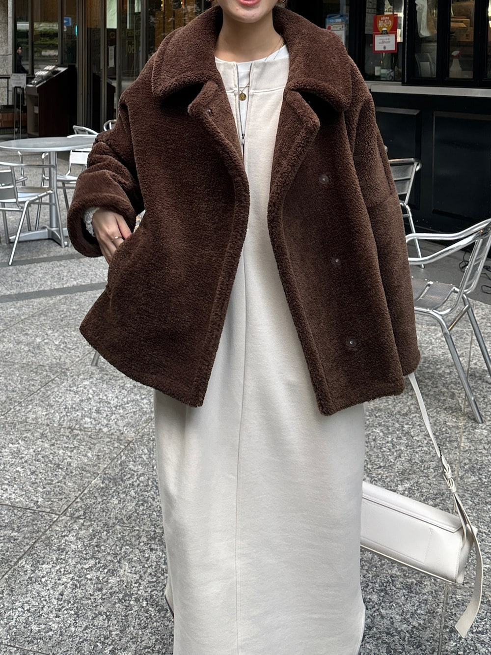 ブラウン系のその他アウター、ベージュ系のワンピース、ブラウン系のブーツを着用したレディースの冬コーディネートの4枚目の写真