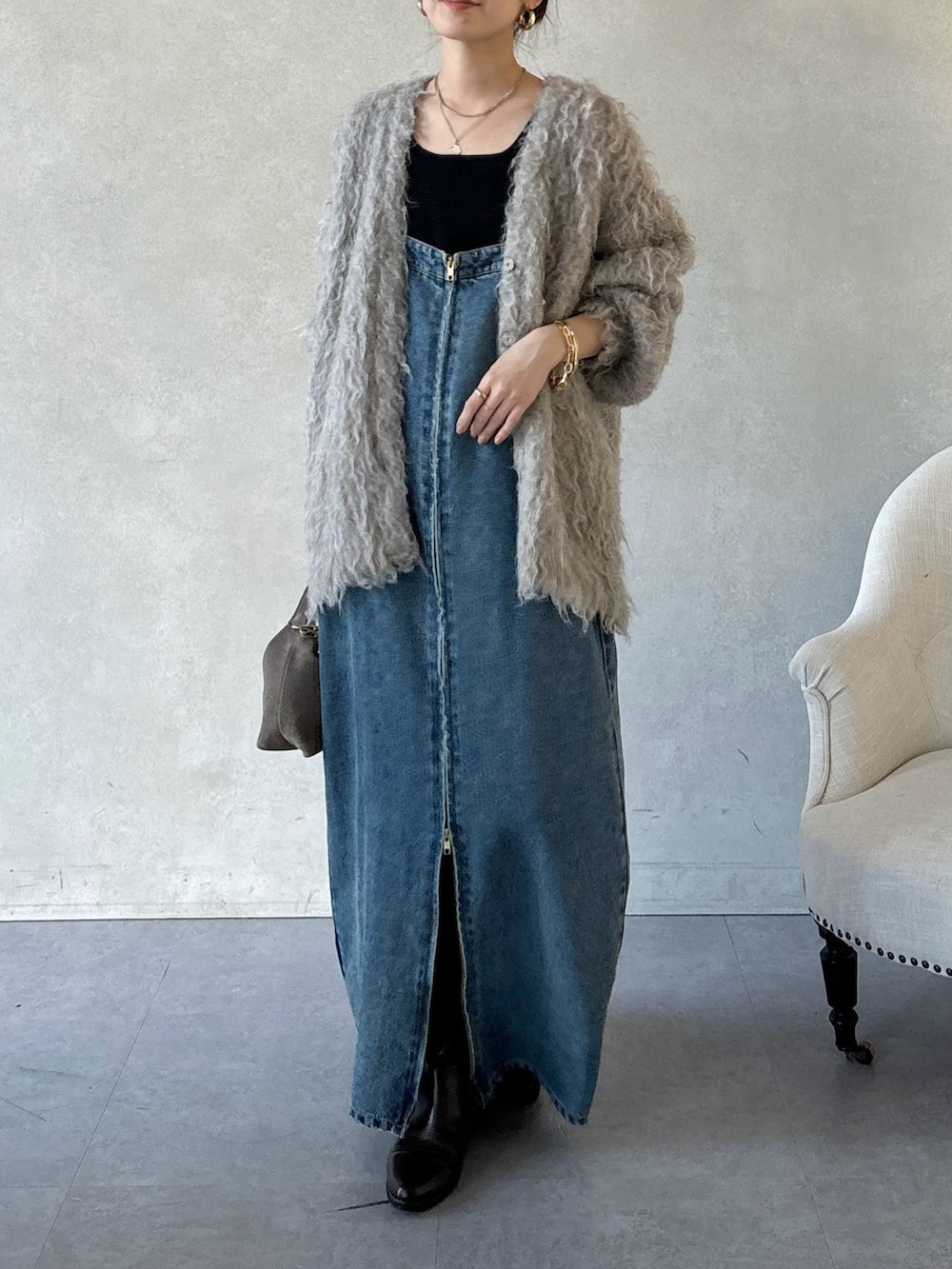 ブラウン系のブーツ、ブルー系のワンピース、ブラウン系のショルダーバッグを着用したレディースの冬コーディネートの2枚目の写真