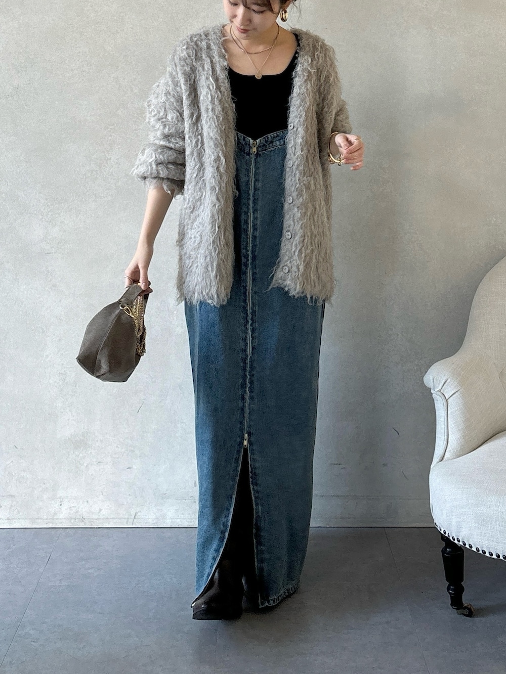 ブラウン系のブーツ、ブルー系のワンピース、ブラウン系のショルダーバッグを着用したレディースの冬コーディネートの4枚目の写真