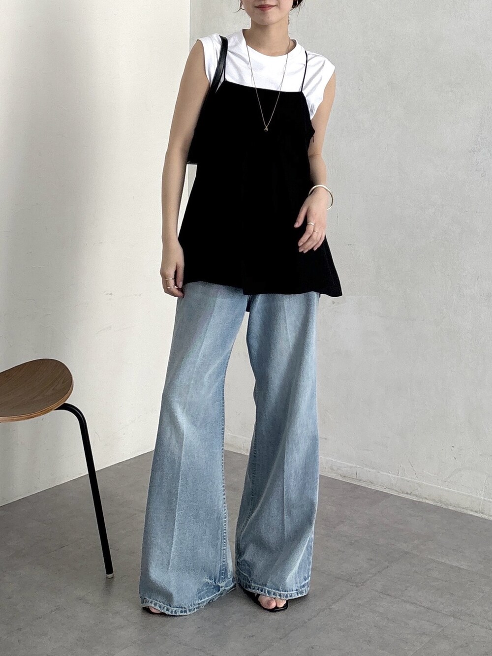 ブルー系のデニムパンツ、ブラック系のキャミソール、ホワイト系のTシャツ/カットソーを着用したレディースの春コーディネートの4枚目の写真