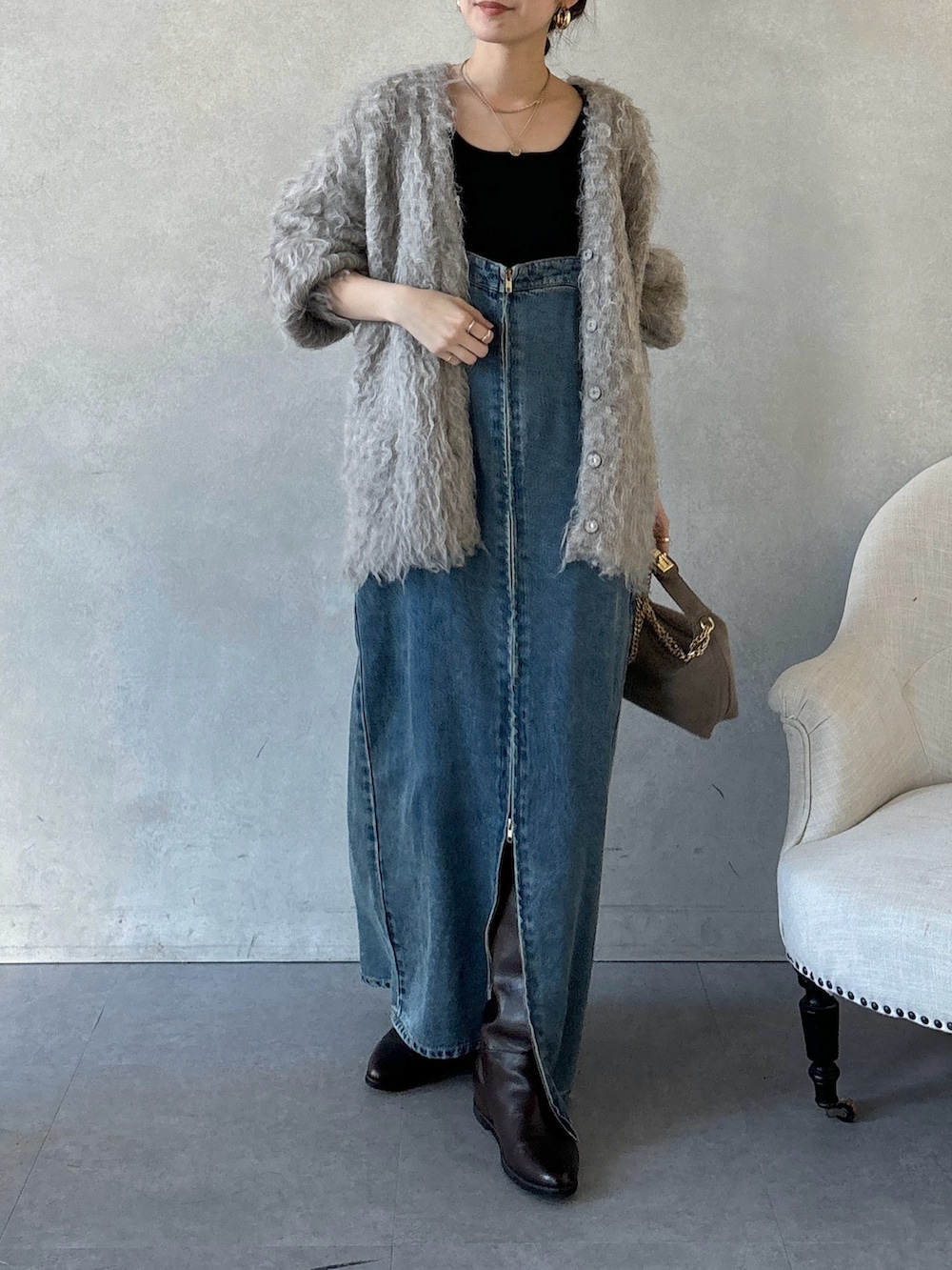 ブラウン系のブーツ、ブルー系のワンピース、ブラウン系のショルダーバッグを着用したレディースの冬コーディネートの6枚目の写真