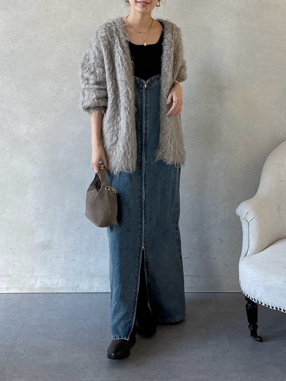 ブラウン系のブーツ、ブルー系のワンピース、ブラウン系のショルダーバッグを着用したレディースの冬コーディネートの5枚目の写真