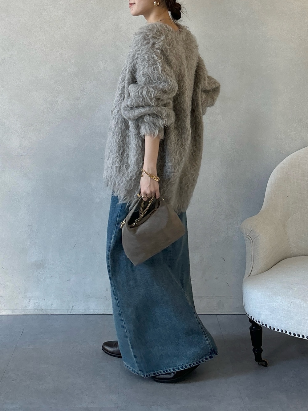 ブラウン系のブーツ、ブルー系のワンピース、ブラウン系のショルダーバッグを着用したレディースの冬コーディネートの7枚目の写真