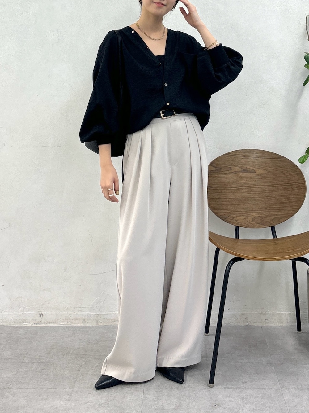 グレー系のスラックス、ブラック系のシャツ/ブラウス、ブラック系のベルトを着用したレディースの秋コーディネートの2枚目の写真