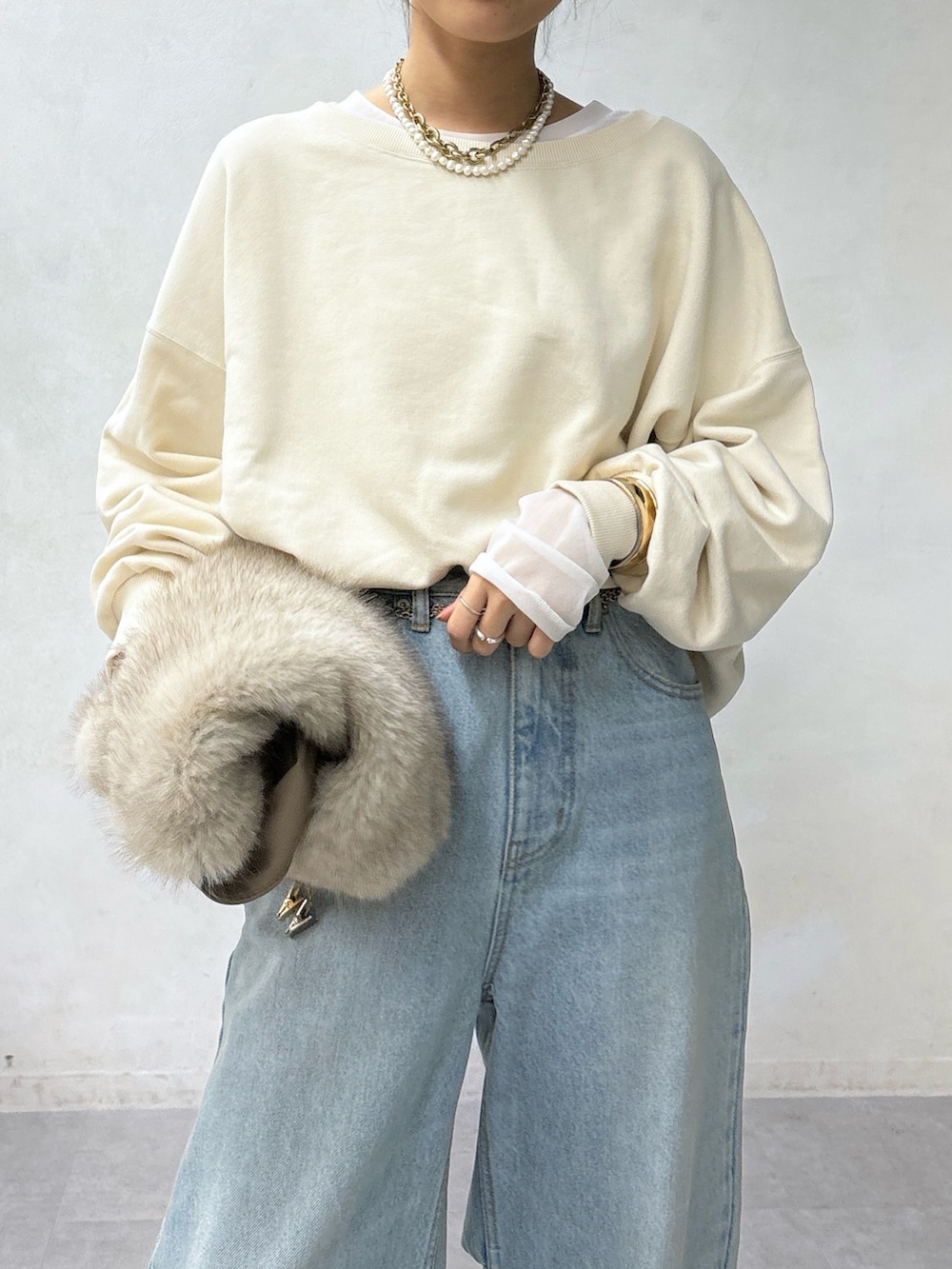 ホワイト系のショルダーバッグ、ブルー系のデニムパンツ、ホワイト系のTシャツ/カットソーを着用したレディースの秋コーディネートの4枚目の写真