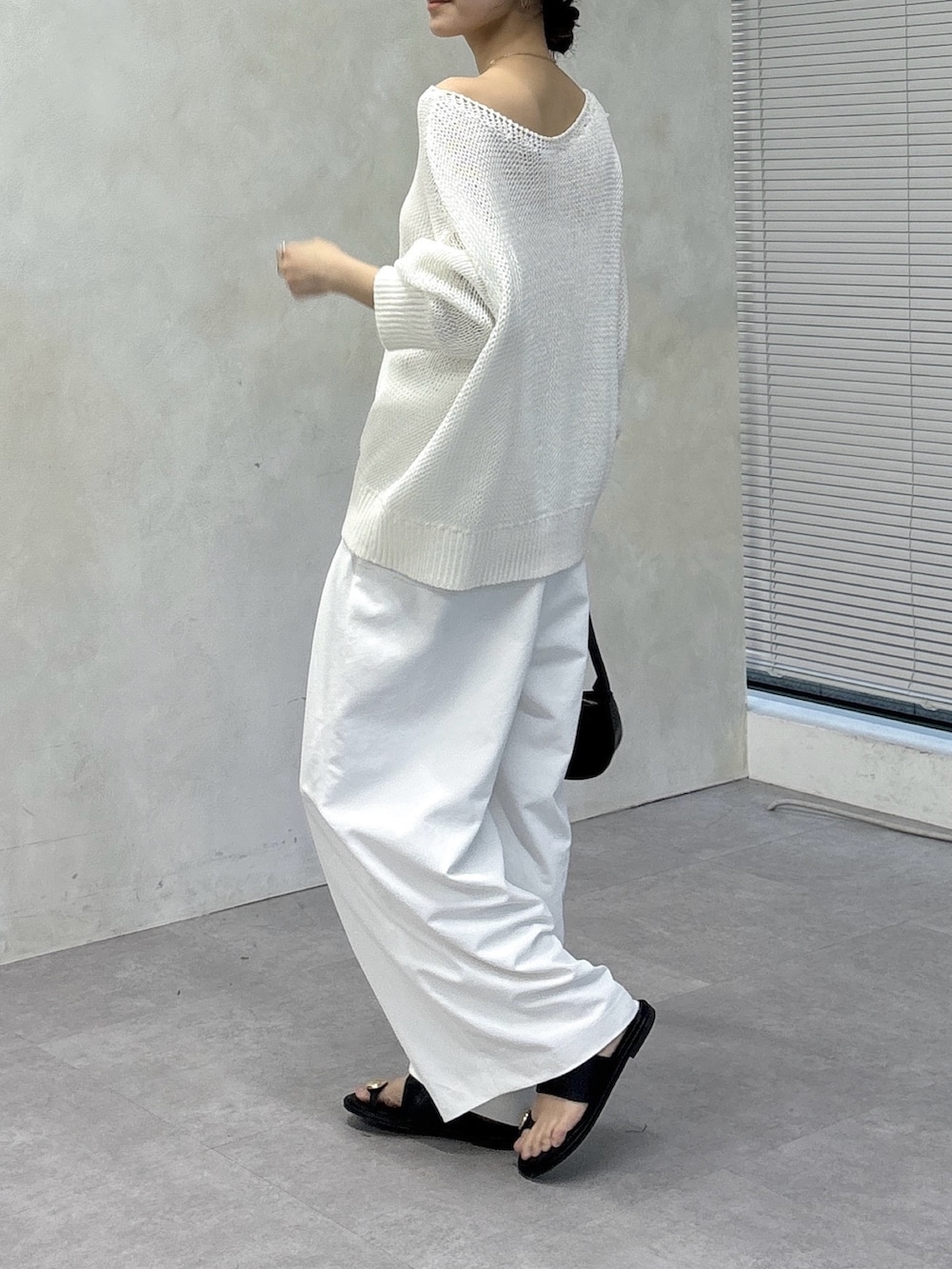 ホワイト系のその他パンツ、ブラック系のサンダル、ホワイト系のニット/セーターを着用したレディースの春コーディネートの4枚目の写真