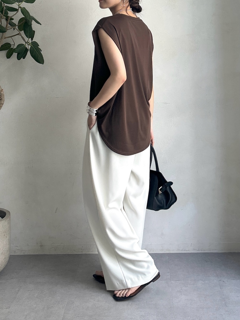 ホワイト系のスラックス、ブラウン系のTシャツ/カットソー、ブラック系のショルダーバッグを着用したレディースの夏コーディネートの4枚目の写真