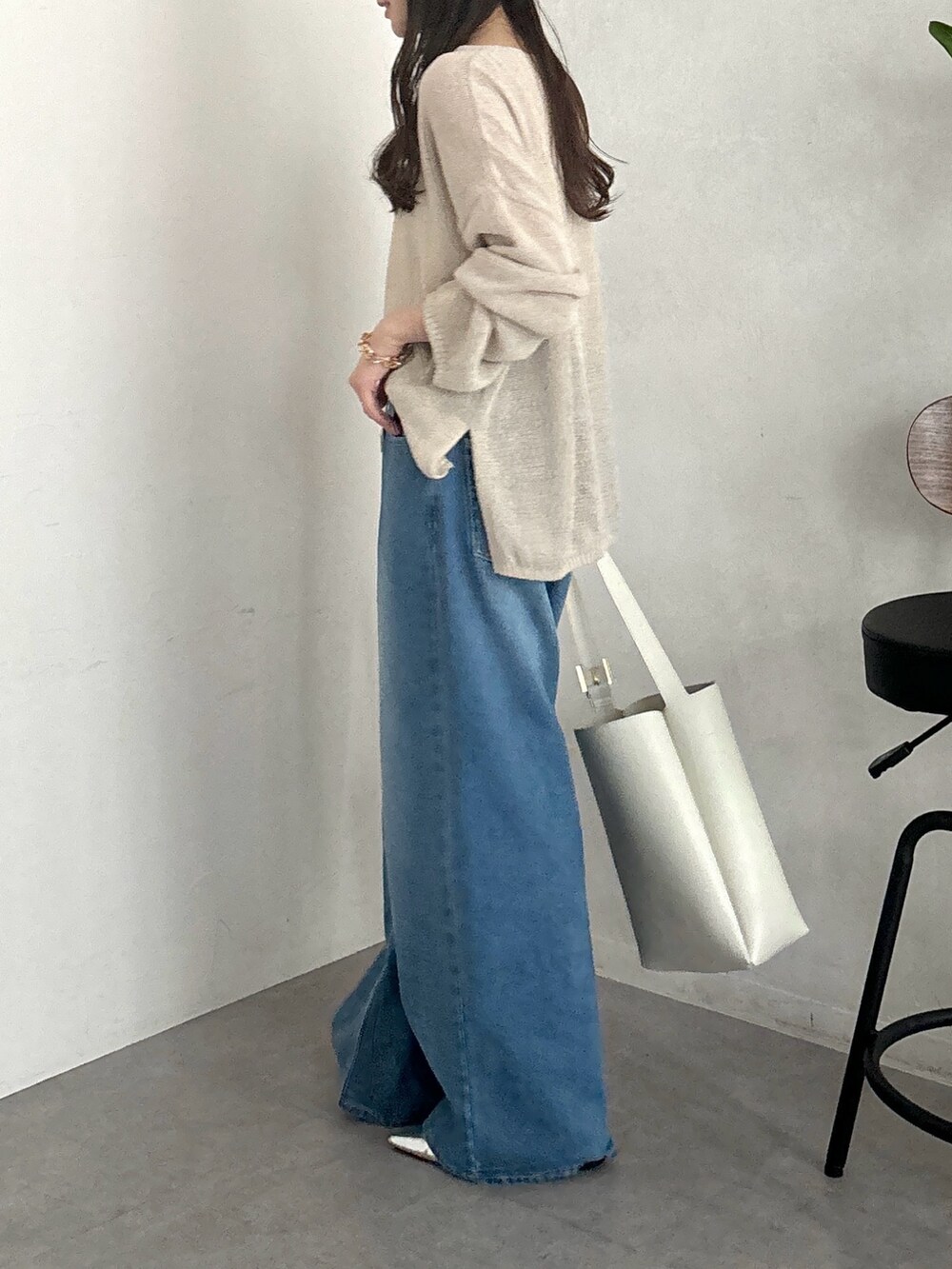 ベージュ系のニット/セーター、ホワイト系のショルダーバッグ、ブルー系のデニムパンツを着用したレディースの春コーディネートの6枚目の写真