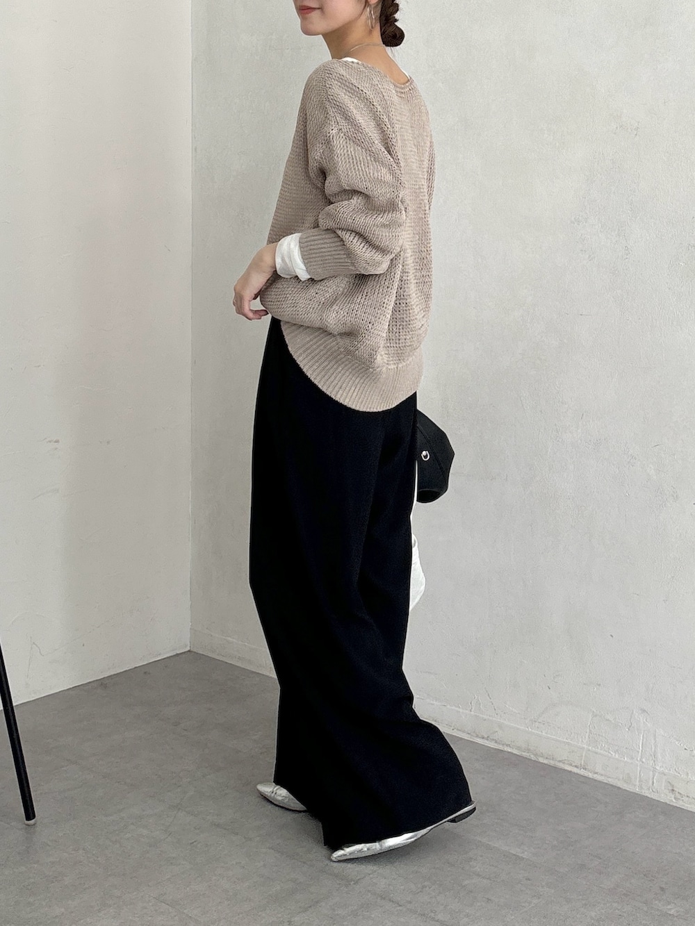 ブラック系のスラックス、ベージュ系のニット/セーター、ホワイト系のTシャツ/カットソーを着用したレディースの春コーディネートの7枚目の写真