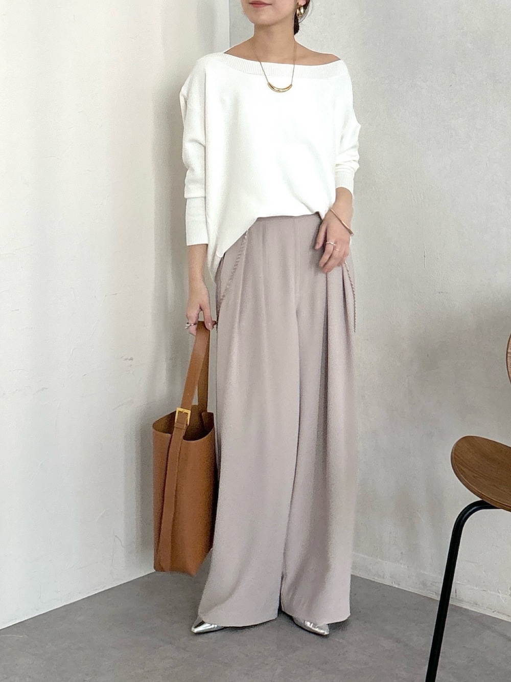 イエロー系のショルダーバッグ、ベージュ系のスラックス、ゴールド系のブレスレットを着用したレディースの冬コーディネートの5枚目の写真