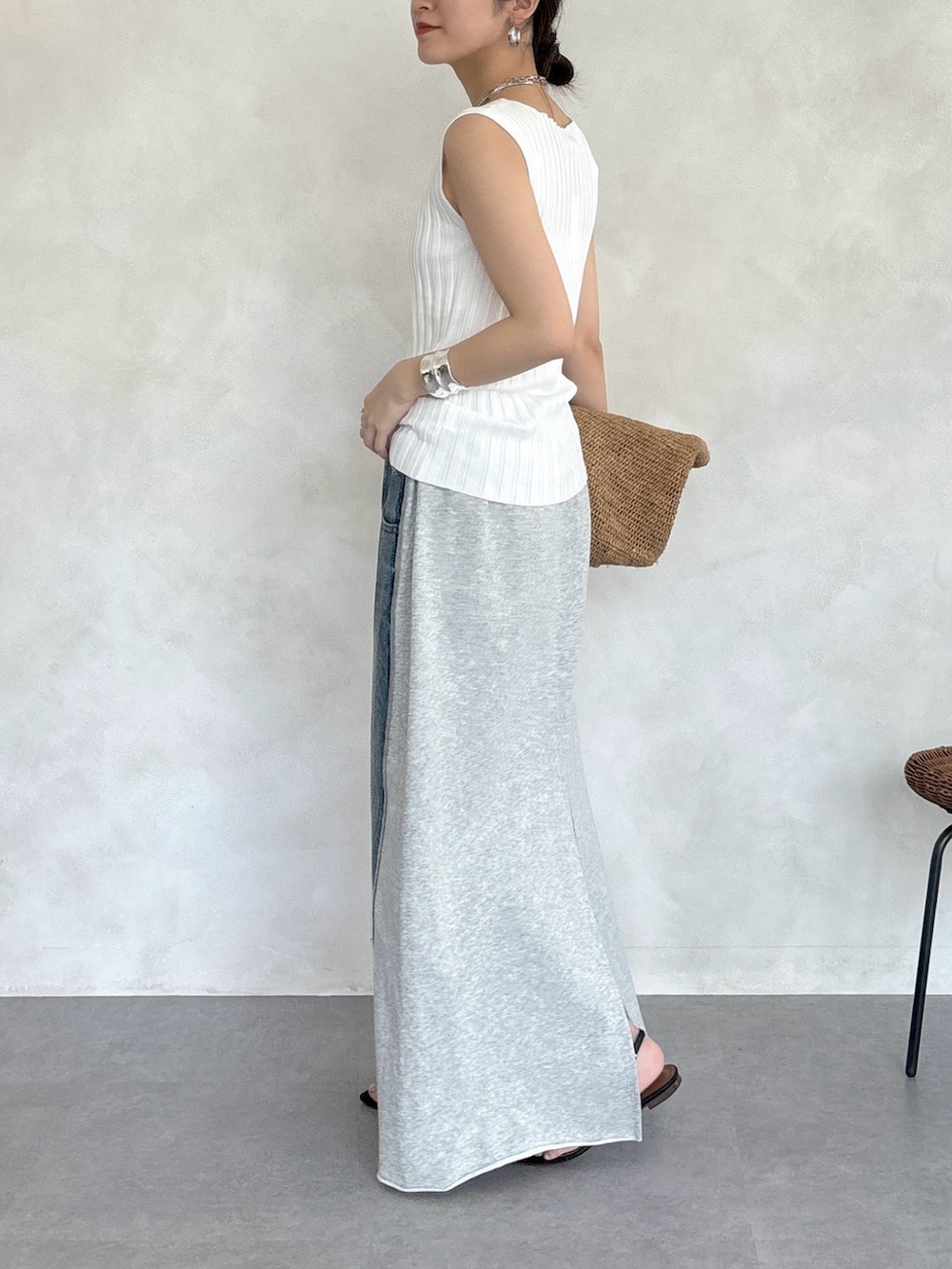 グレー系のスカート、ホワイト系のニット/セーター、シルバー系のネックレスを着用したレディースの春コーディネートの6枚目の写真