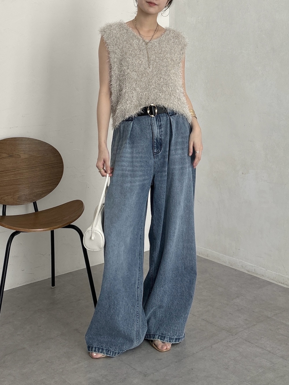 ブルー系のデニムパンツ、ベージュ系のニット/セーターを着用したレディースの夏コーディネートの3枚目の写真
