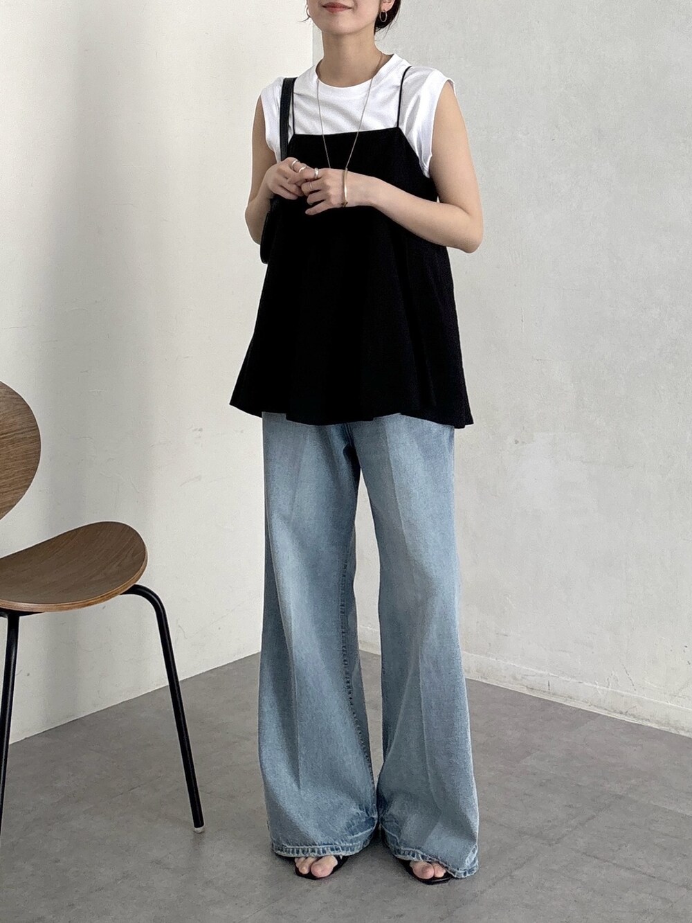 ブルー系のデニムパンツ、ブラック系のキャミソール、ホワイト系のTシャツ/カットソーを着用したレディースの春コーディネートの5枚目の写真