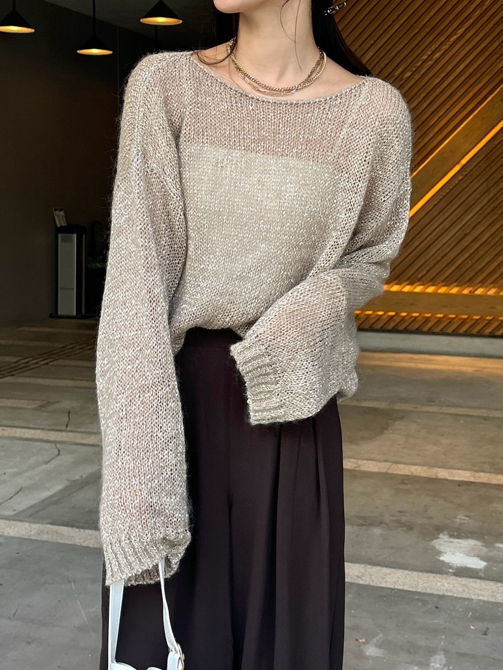 ブラウン系のスラックス、ベージュ系のニット/セーター、ホワイト系のショルダーバッグを着用したレディースの夏コーディネートの9枚目の写真