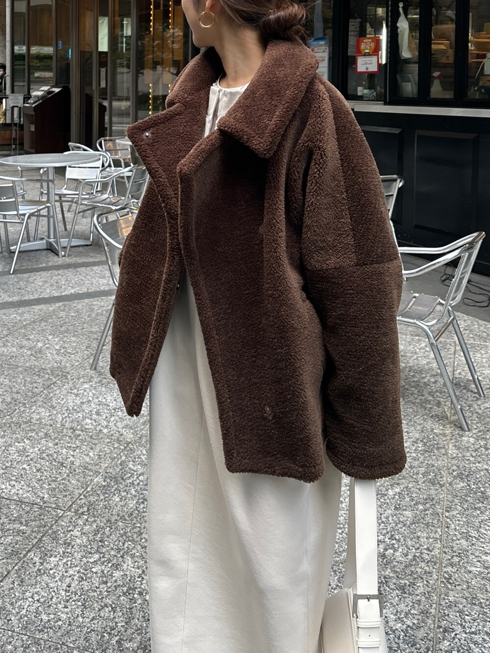 ブラウン系のその他アウター、ベージュ系のワンピース、ブラウン系のブーツを着用したレディースの冬コーディネートの3枚目の写真