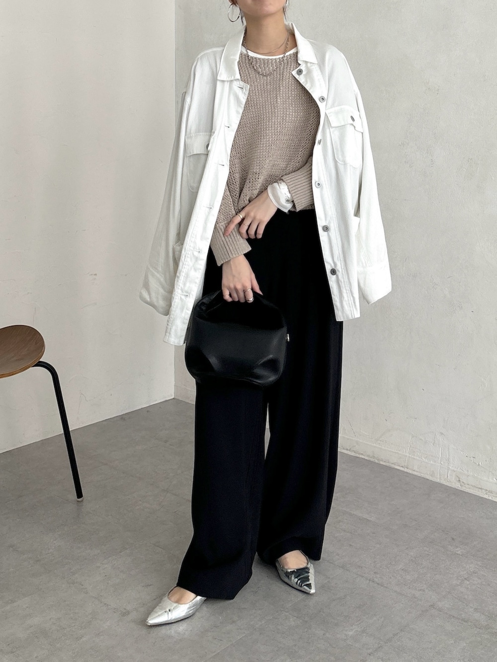 ブラック系のスラックス、ベージュ系のニット/セーター、ホワイト系のTシャツ/カットソーを着用したレディースの春コーディネートの3枚目の写真