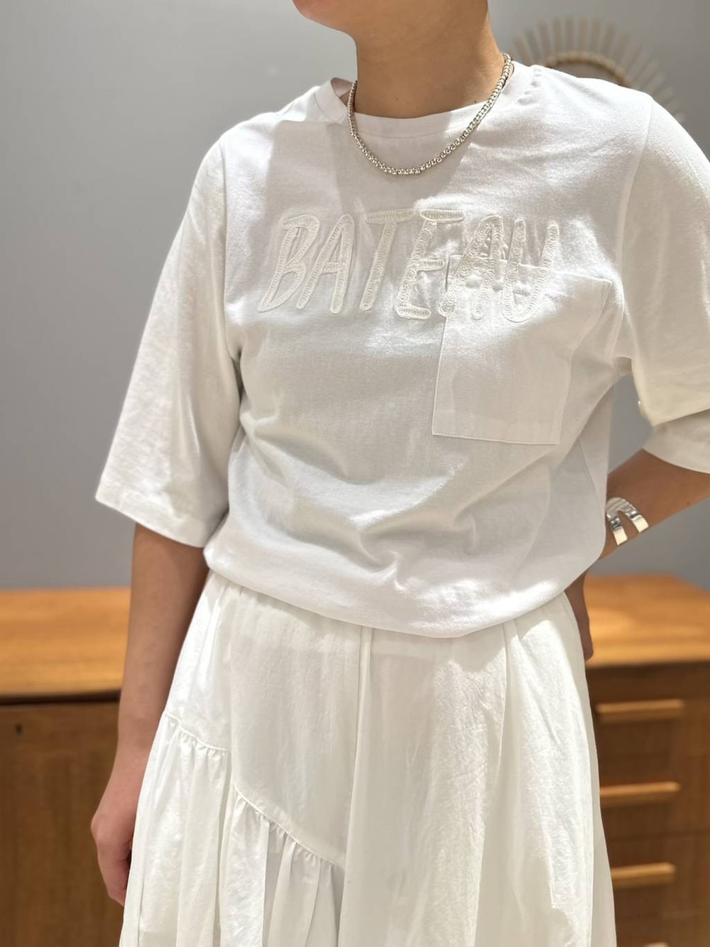 ホワイト系のスカート、ホワイト系のTシャツ/カットソー、グレー系のテーラードジャケットを着用したレディースの夏コーディネートの5枚目の写真