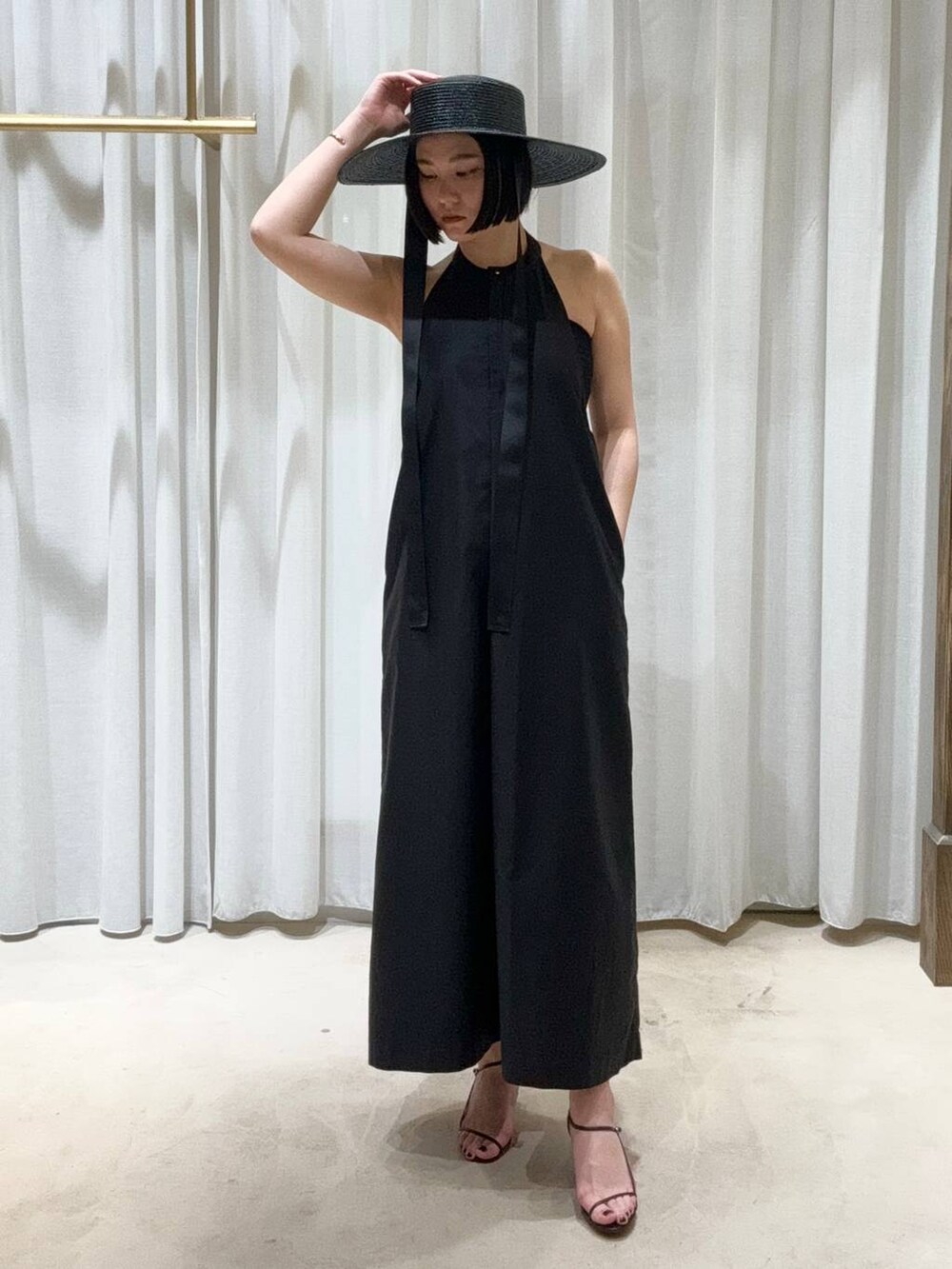 ブラック系のサンダル、ブラック系のワンピースを着用したレディースの春コーディネートの2枚目の写真