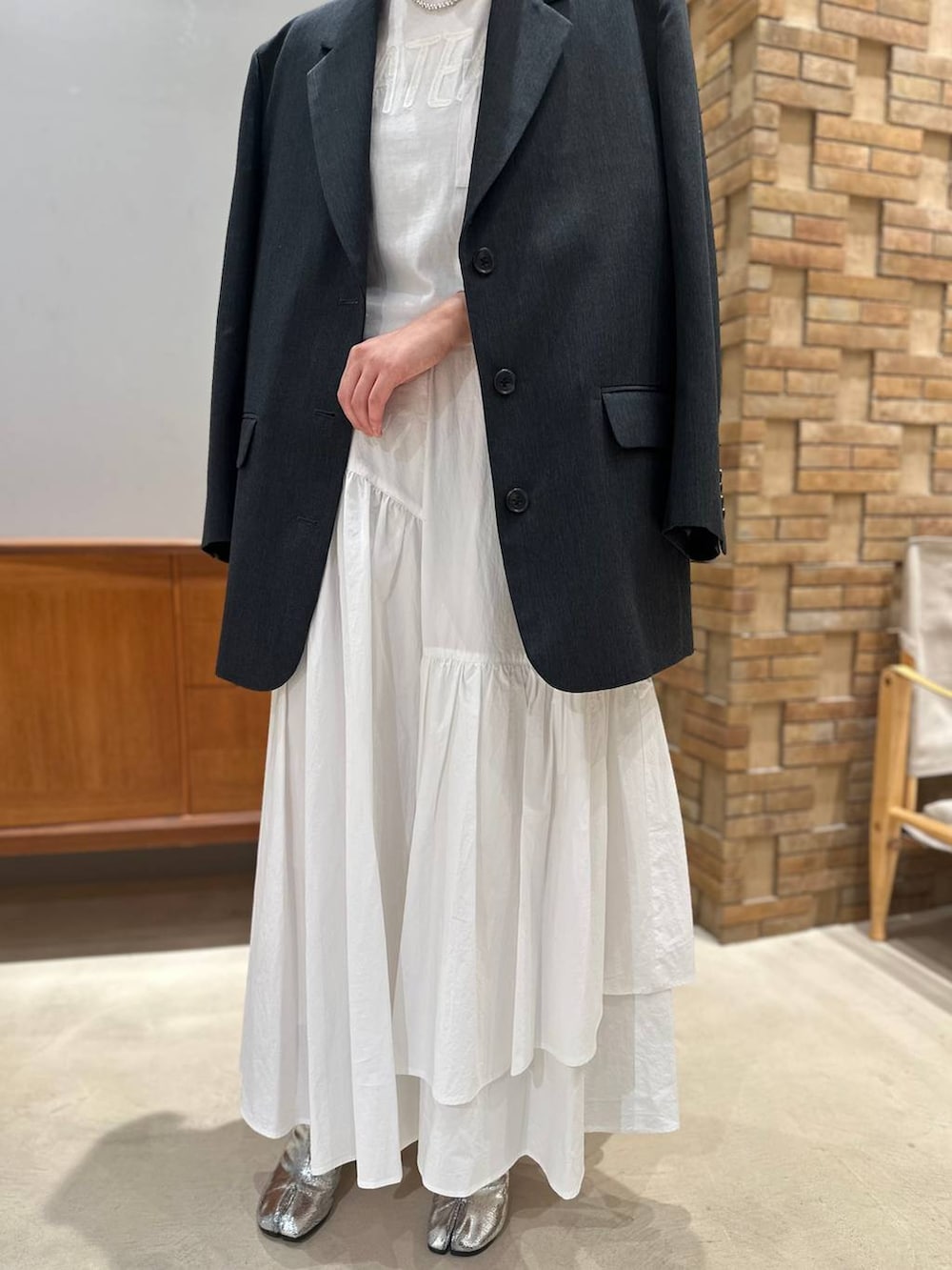 ホワイト系のスカート、ホワイト系のTシャツ/カットソー、グレー系のテーラードジャケットを着用したレディースの夏コーディネートの4枚目の写真