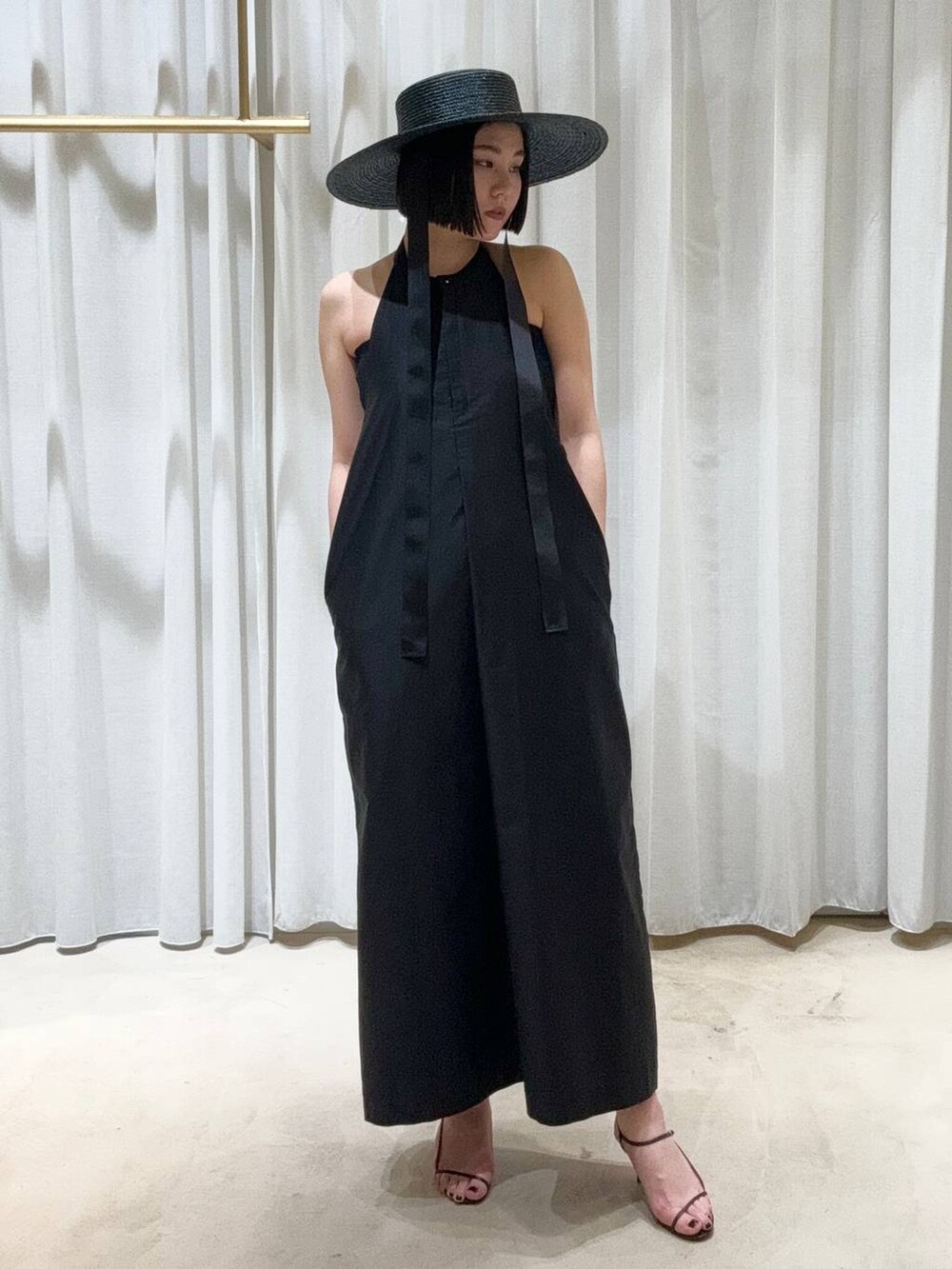 ブラック系のサンダル、ブラック系のワンピースを着用したレディースの春コーディネートの3枚目の写真