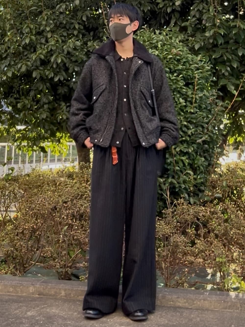 グレー系のニット/セーター、グレー系のブルゾン、ブラック系のスラックスを着用したメンズの秋コーディネートの2枚目の写真