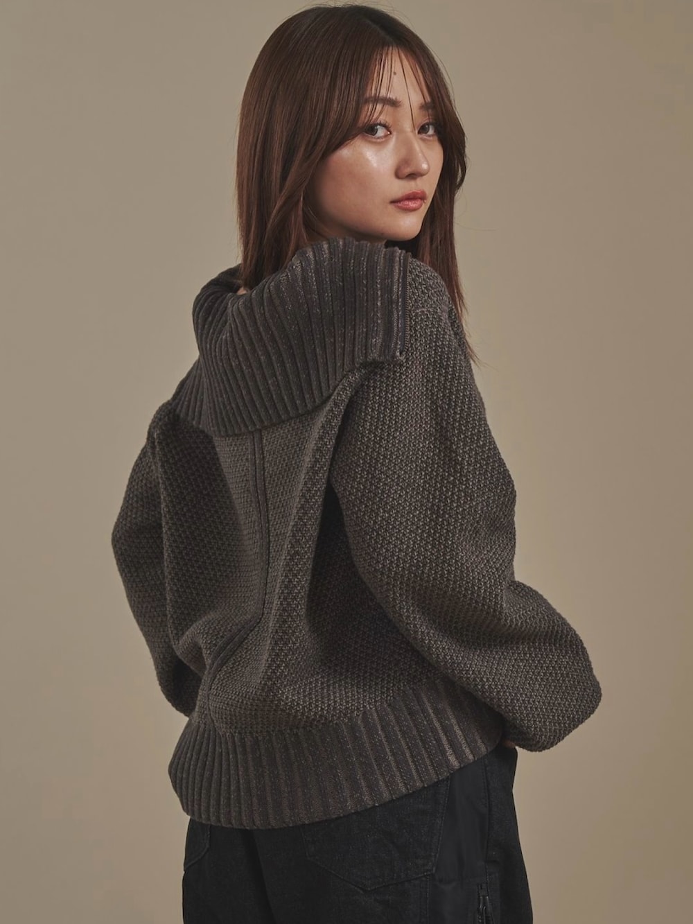 グレー系のニット/セーター、ブラック系のデニムパンツを着用したレディースの秋コーディネートの3枚目の写真