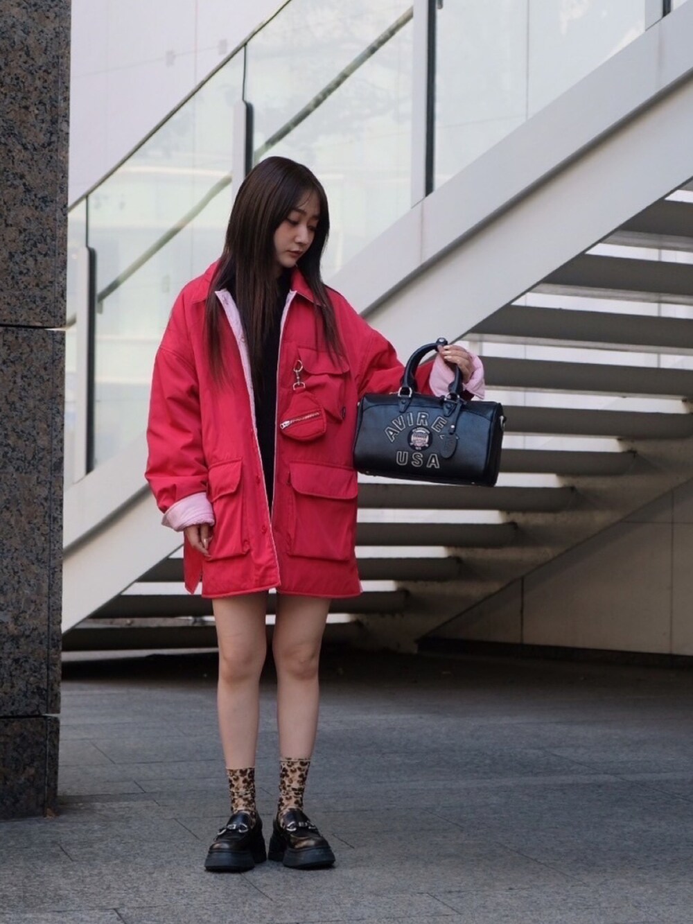 レッド系のナイロンジャケット、ブルー系のキャップを着用したレディースの冬コーディネートの5枚目の写真