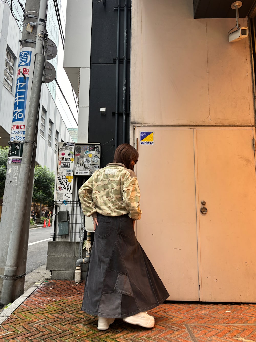 ブラック系のデニムスカート、ベージュ系のTシャツ/カットソーを着用したレディースの秋コーディネートの5枚目の写真