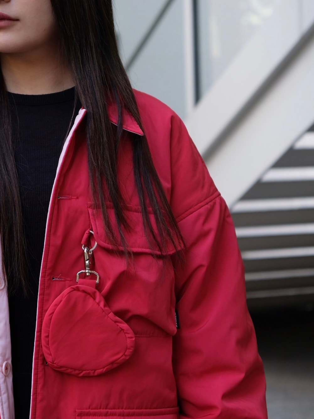 レッド系のナイロンジャケット、ブルー系のキャップを着用したレディースの冬コーディネートの3枚目の写真