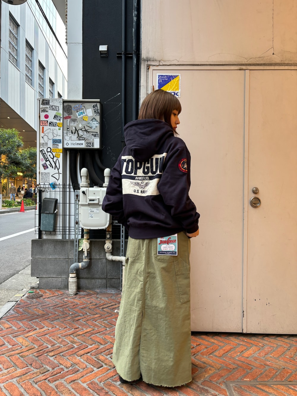 ブルー系のパーカー、グリーン系のスカートを着用したレディースの春コーディネートの2枚目の写真