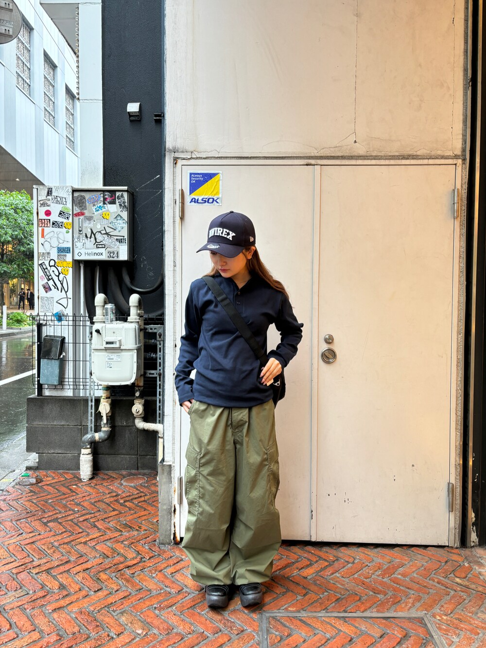 ブラック系のショルダーバッグ、ブルー系のTシャツ/カットソー、ブルー系のキャップを着用したレディースの春コーディネートの3枚目の写真