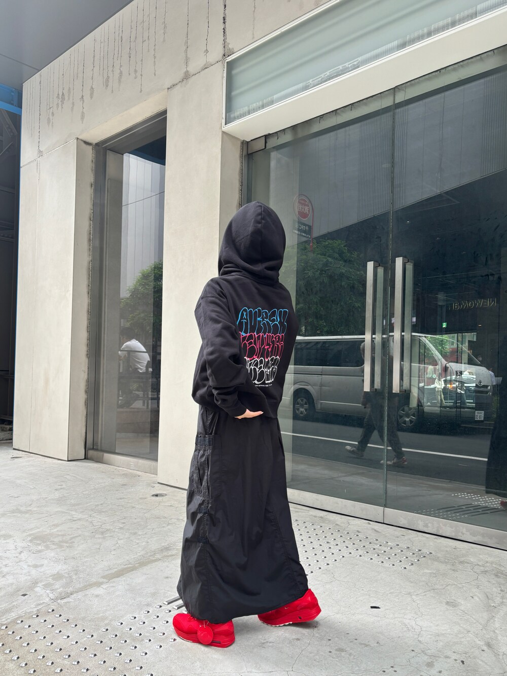 ブラック系のスカート、ブラック系のパーカーを着用したレディースの夏コーディネートの3枚目の写真