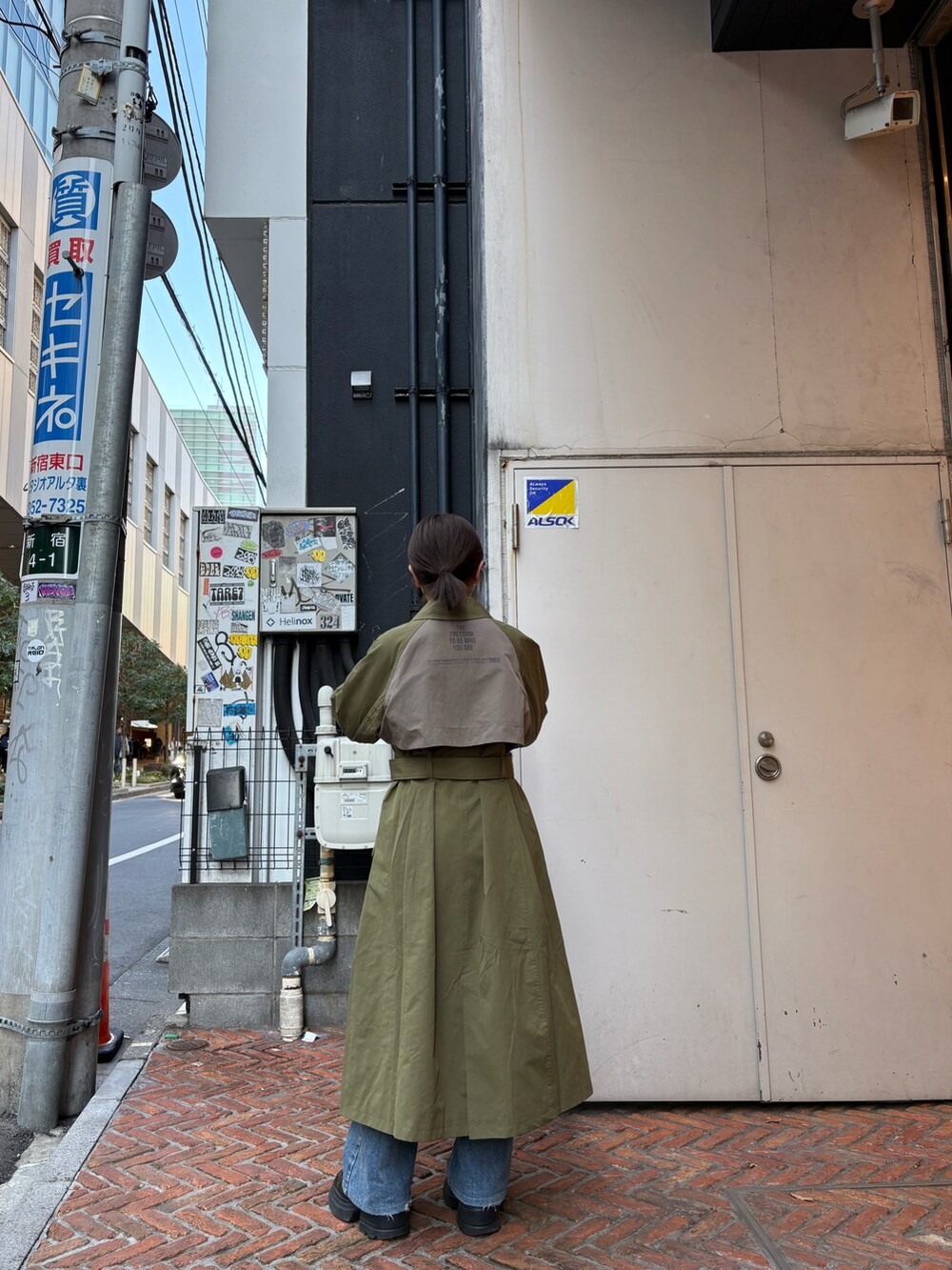 グリーン系のトレンチコートを着用したレディースの冬コーディネートの3枚目の写真