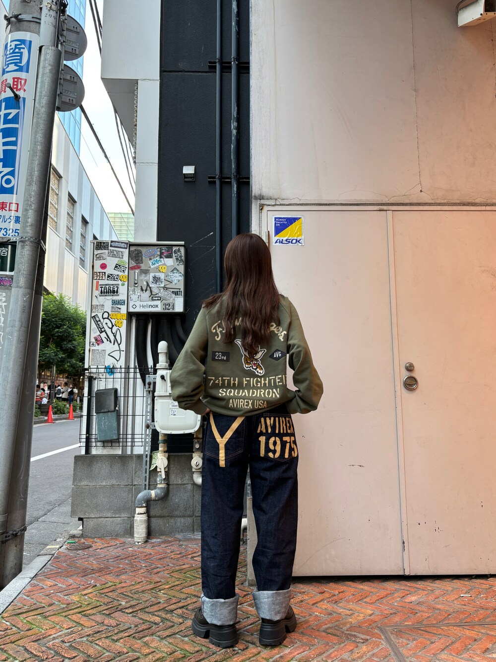 グリーン系のスウェット、ブルー系のデニムパンツを着用したレディースの秋コーディネートの4枚目の写真