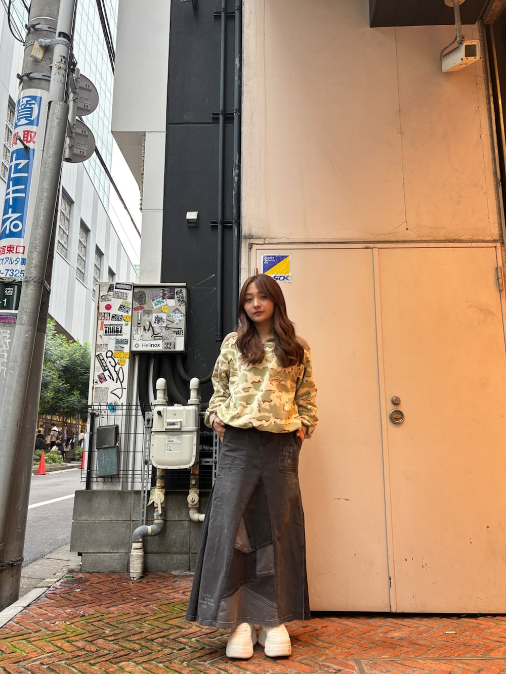 ブラック系のデニムスカート、ベージュ系のTシャツ/カットソーを着用したレディースの秋コーディネートの2枚目の写真