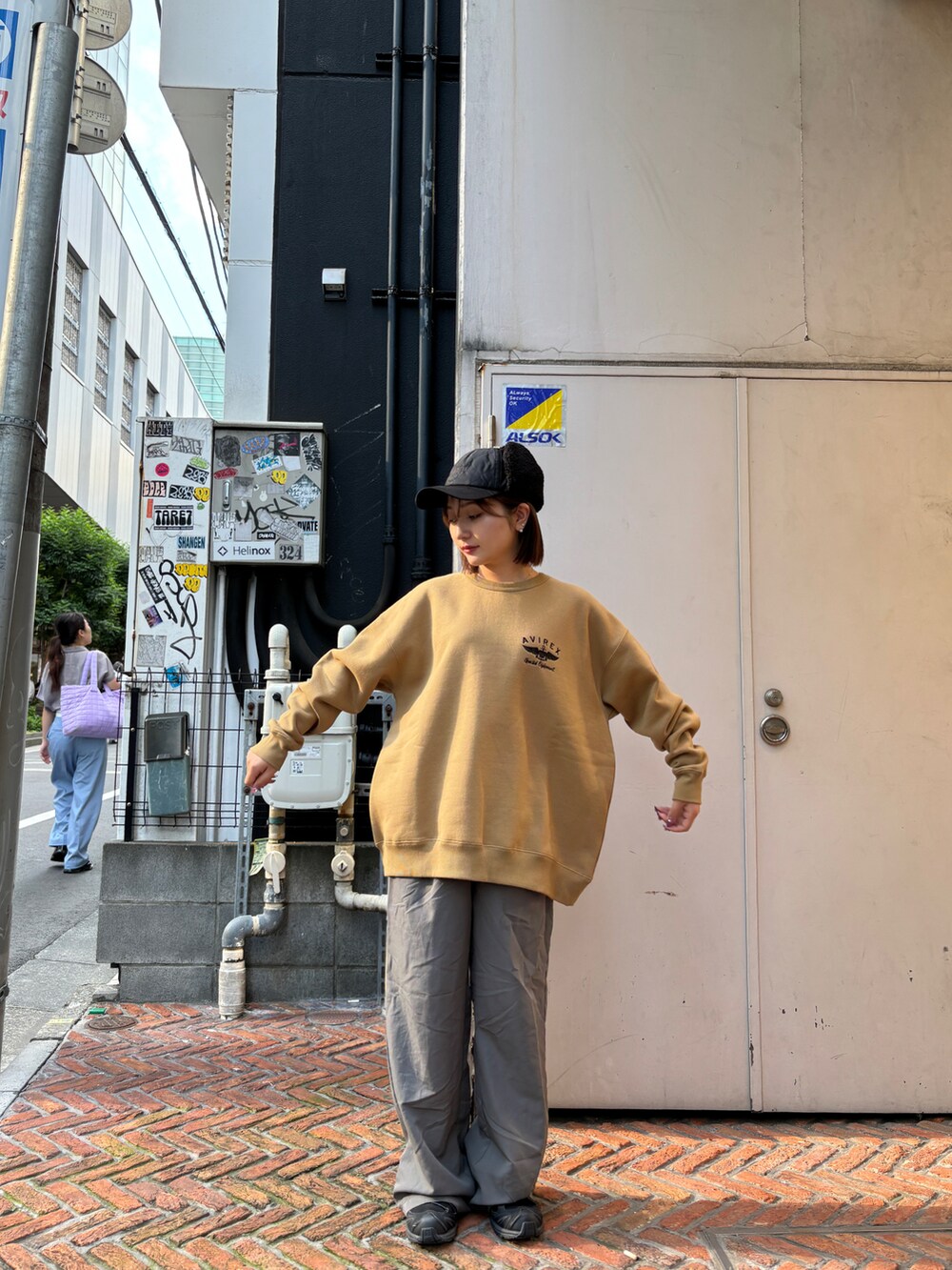 グリーン系のスウェット、ブラック系のキャップを着用したレディースの秋コーディネートの2枚目の写真