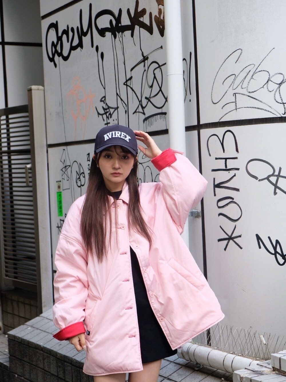 レッド系のナイロンジャケット、ブルー系のキャップを着用したレディースの冬コーディネートの2枚目の写真