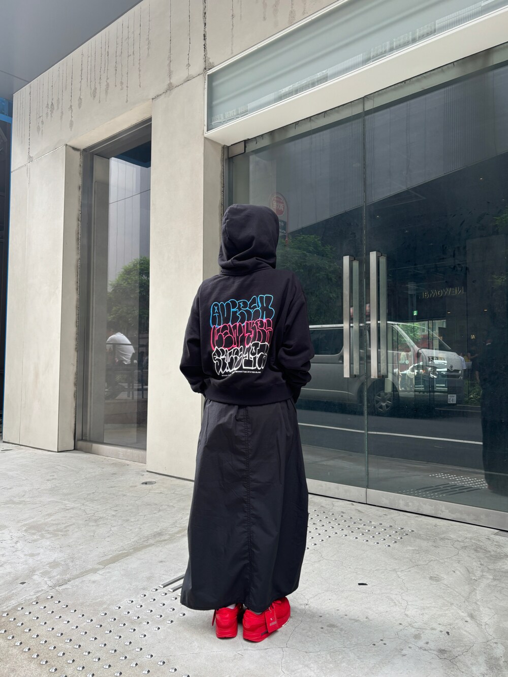 ブラック系のスカート、ブラック系のパーカーを着用したレディースの夏コーディネートの2枚目の写真