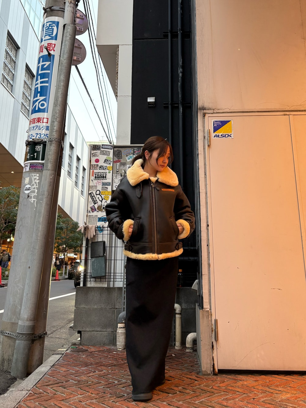 ブラウン系のムートンコートを着用したレディースの冬コーディネートの2枚目の写真